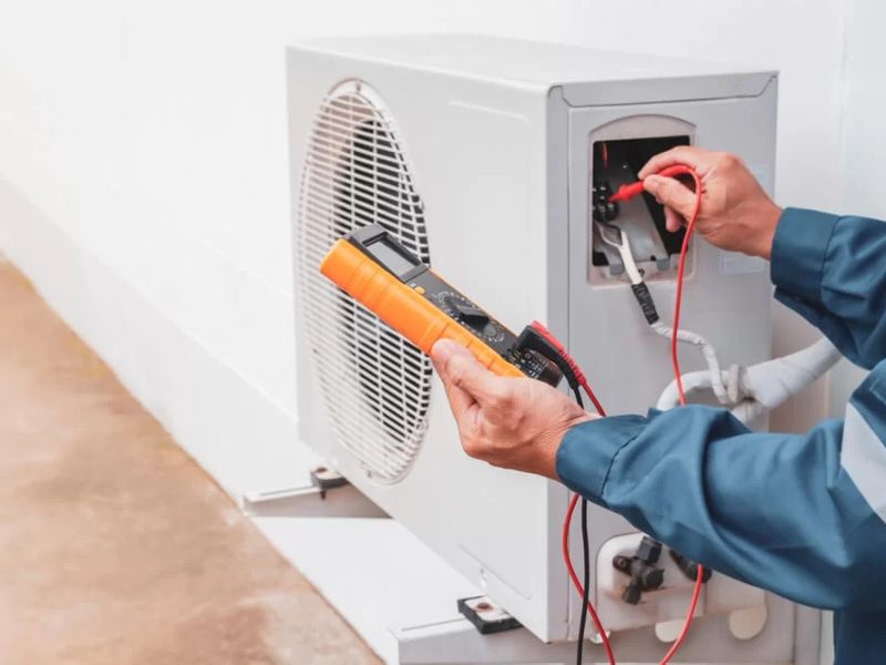 Technician testing an outdoor AC unit